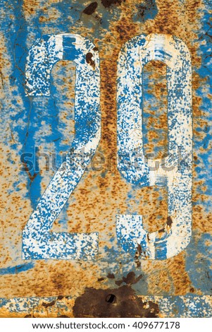 White 29 number painted onto a rusty blue and orange metal background.