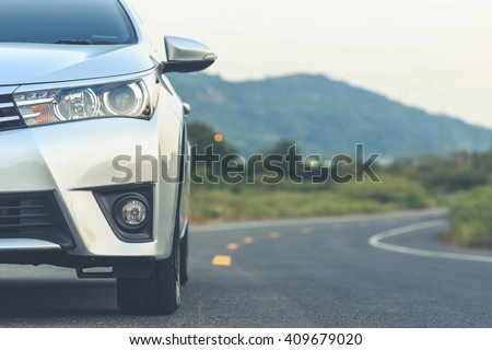 Close up front of new silver car parking on the asphalt road Royalty-Free Stock Photo #409679020