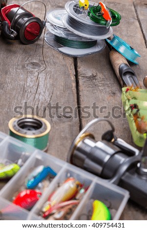 fishing tackles and fishing baits in box on wooden board background. Design for outdoor sport business - templates, web, poster, card, advertisement.