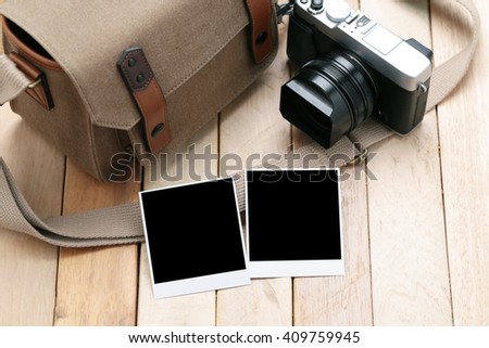 Camera and Photo frame on wooden table.