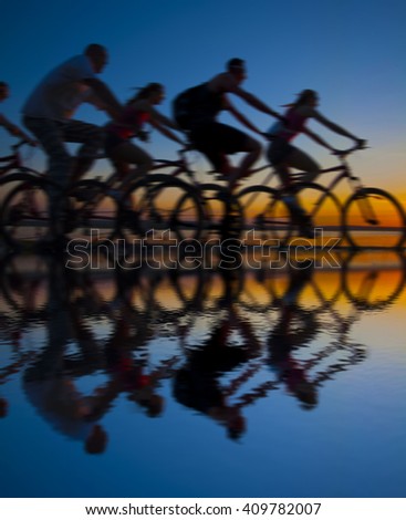 Empty Copy Space Sporty company friends on bicycles outdoors against sunset Silhouette five 5 cyclist going along shoreline coast Reflection sun on water Sport in Nature background Group of people