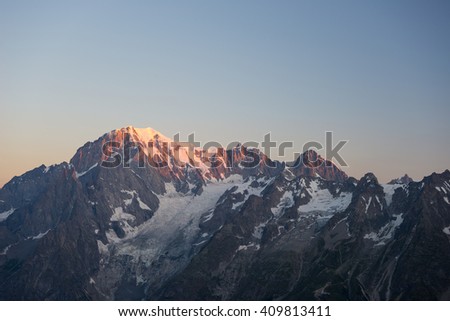 First soft light at sunrise over Monte Bianco or Mont Blanc summit (4810 m) and his melting glaciers. View from 3000 m in Valle d'Aosta. Summer adventures on the italian french Alps.