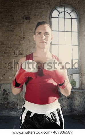 Boxer ready to fight standing in an old abandoned hall and waiting for the start of fighting