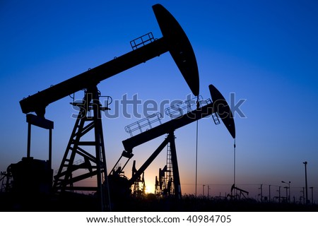 Silhouette of oil pump jacks with sunset