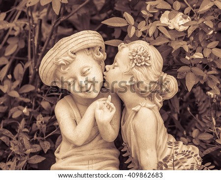 Vintage picture of Boy and girl statues in a park