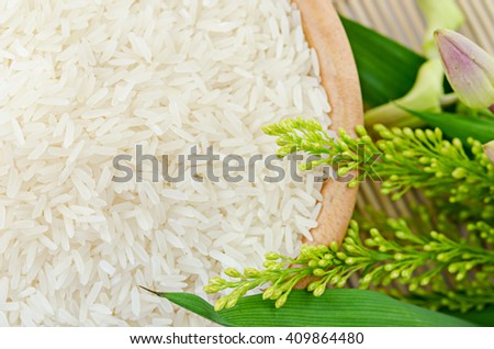 raw white rice in a bowl with flower - top view
