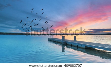 wooden jetty at lake, photographed in the evening, sunset in summer                         
