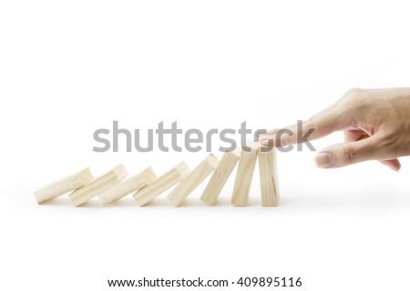 Hand stop falling wood domino pieces isolated on white background