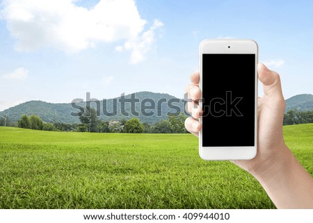 Selfie with mobile smart phone on green park and sky background
