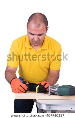 Carpenter marking wood with a tape measure isolated on white background