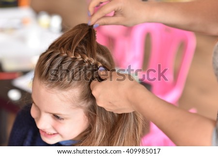 
braiding pigtails Royalty-Free Stock Photo #409985017