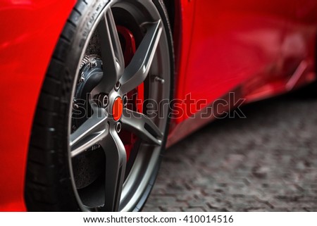 Detail on hot red super-sport car wheels with sport breaks Royalty-Free Stock Photo #410014516