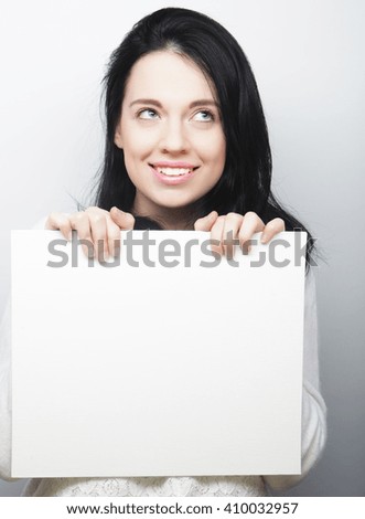 Smiling young casual style woman showing blank signboard