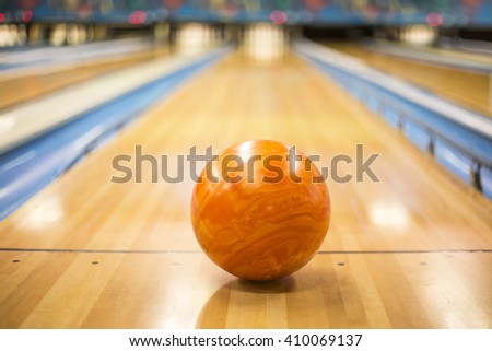Bowling ball sitting in a colorful bowling alley lane