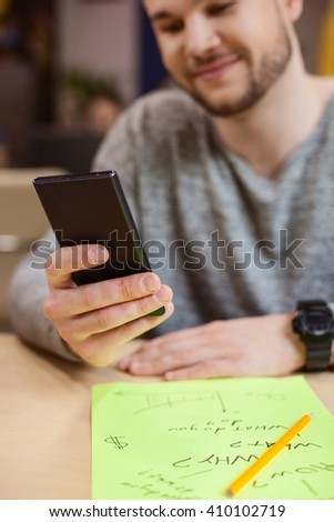 Attractive young guy is using a telephone