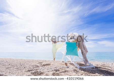 WOman with sun lounger chair on the beach - Focused on the chair