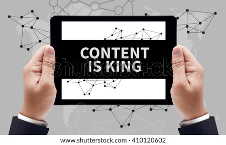 CONTENT IS KING concept on the tablet pc screen by businessman hands, top view