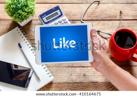 Business  technology and concept.Tablet with text inside Like on the table with offee. Royalty-Free Stock Photo #410164675