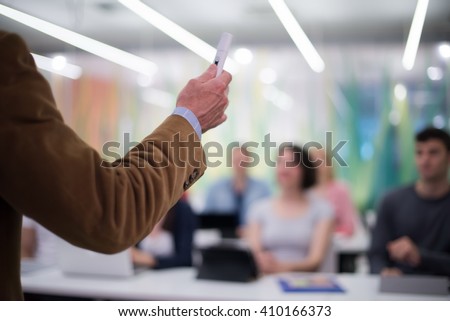 close up of teacher hand with marker while teaching lessons in school  classroom to students Royalty-Free Stock Photo #410166373