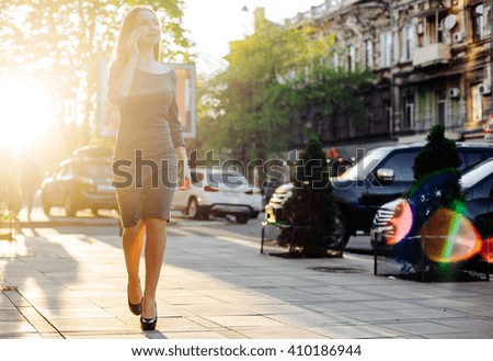 woman in city speaking on phone in sunset light