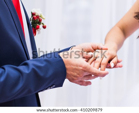 picture of man putting  wedding ring on woman hand