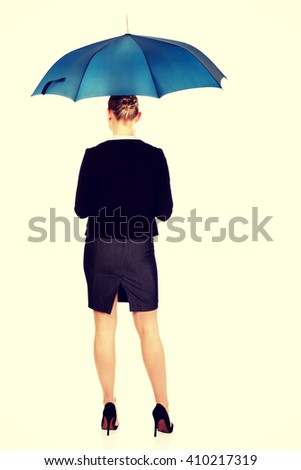 Back view of business woman holding an umbrella