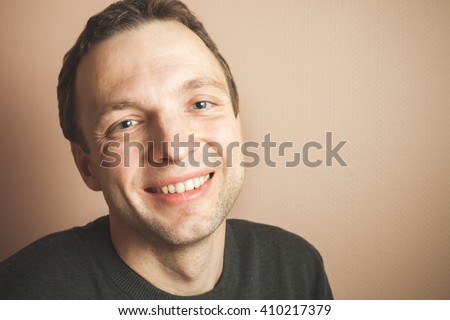 Young handsome smiling man studio portrait over gray wall background, vintage tonal correction, old style photo filter effect