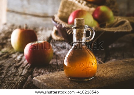Apple vinegar. Bottle of apple organic vinegar on wooden background. Healthy organic food. Royalty-Free Stock Photo #410218546