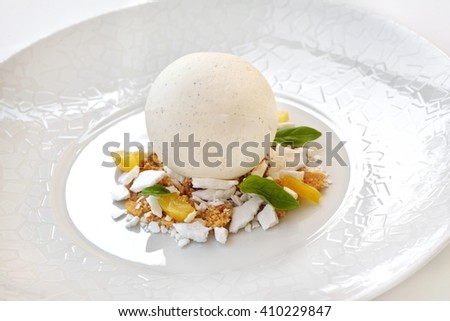 Vanilla ice cream, basil and lemon on a plate