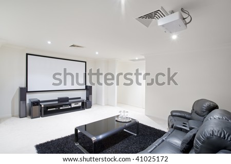 home theater room with black leather recliner chairs, black rug and table with wine glasses Royalty-Free Stock Photo #41025172