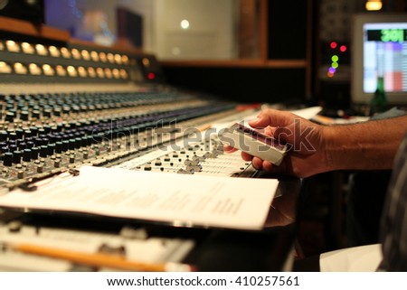 Close up of hand at music studio recorder. Producer and orchestrator