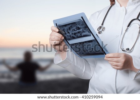 Doctor with X-ray picture in hands on a defocused background. Selective focus.