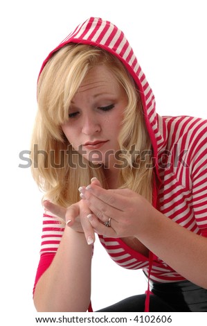 A young woman inspecting a hangnail on her finger