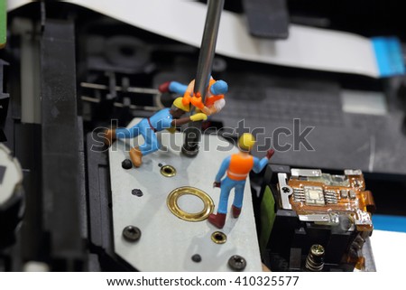 Selective focus of miniature engineer and worker fixed to remove screw by screwdriver for repair cd rom of computer and use for business background.