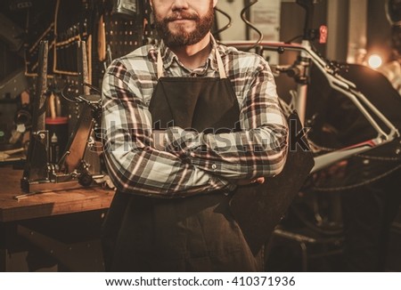 Stylish bicycle mechanic standing in his workshop. 