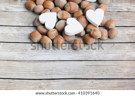 Hazelnuts. Hazelnuts and wooden hearts. White wooden hearts. Shabby hazelnuts. 