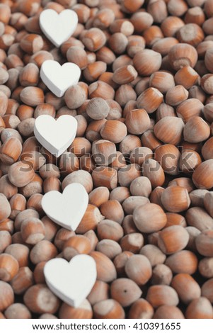 Hazelnuts. Hazelnuts and wooden hearts. White wooden hearts. Shabby hazelnuts. 