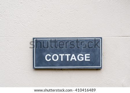 Cottage Sign on a stone rendered  wall