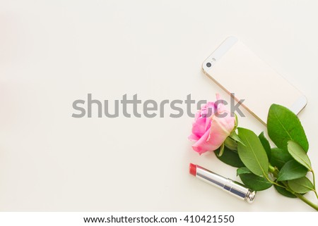 Styled desktop scene  with  mobile and pink flowers, copy space on white table
