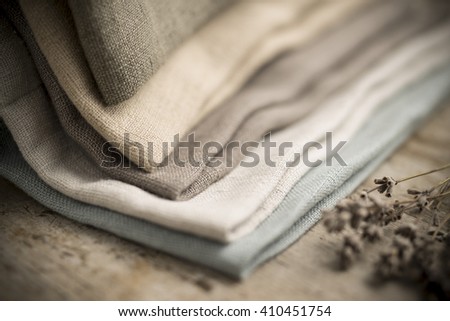 Closeup shot of a pile of folded dull-colored cotton fabric. Royalty-Free Stock Photo #410451754
