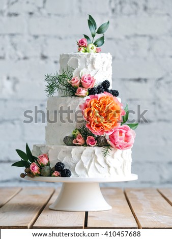 White wedding cake with flowers and blueberries Royalty-Free Stock Photo #410457688
