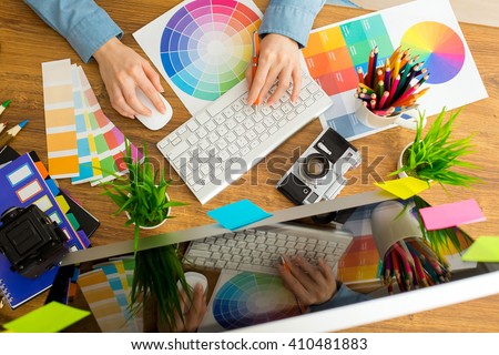 Young cute Graphic designer using graphics tablet to do his work at desk Royalty-Free Stock Photo #410481883