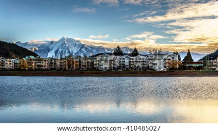 The village of Harrison Hot Springs in the Fraser Valley of British Columbia with the lagoon in the foreground and majestic Mount Cheam in the background Royalty-Free Stock Photo #410485027