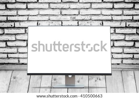 Blank space Display monitor on wood floors and black and white brick wall texture.