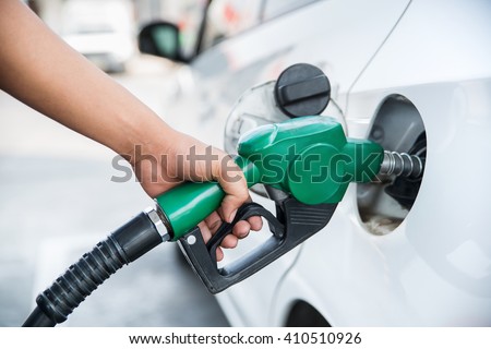 Handle fuel nozzle to refuel. Vehicle fueling facility. Royalty-Free Stock Photo #410510926
