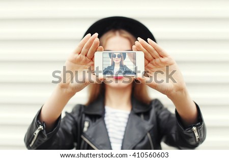 Fashion woman makes self portrait on smartphone view of screen