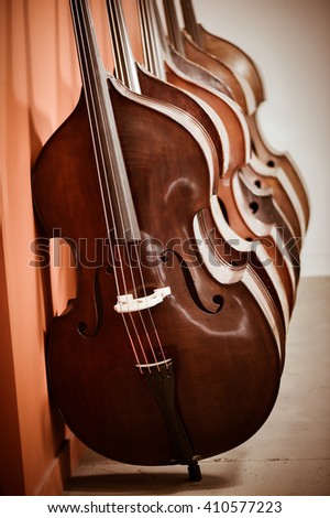Close up of a group of cellos in the workshop of violin maker