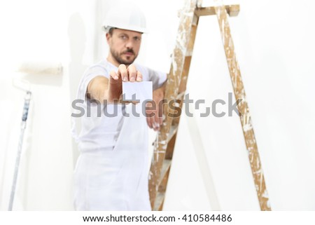 painter man hand with business card, ladder on white wall background,