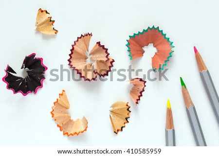 Creativity Concept Image of color Pencils and shaped wood Chips and Shavings of sharpening a pencil on white Table