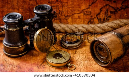 Vintage grunge still life. Antique items on old world map. Travel geography concept.